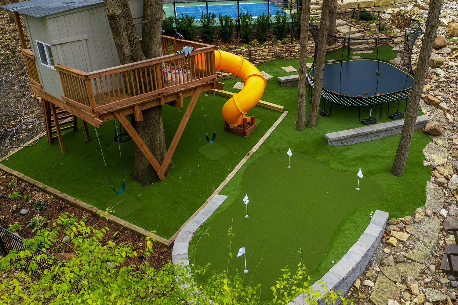 Artificial grass backyard with playground and putting green