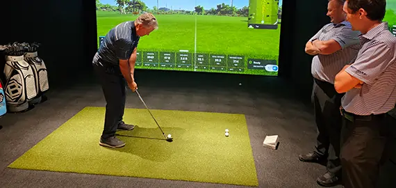 Golfers practicing on golf simulator
