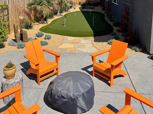 artificial grass backyard area with orange chairs